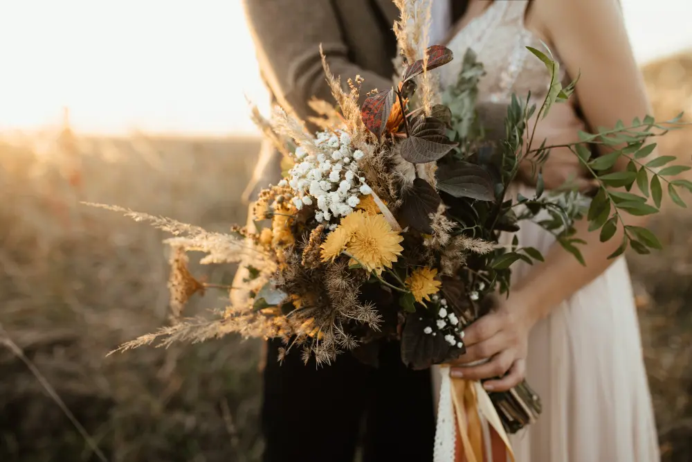 Pareja de casados cogiendo el ramo de flores el día de su boda